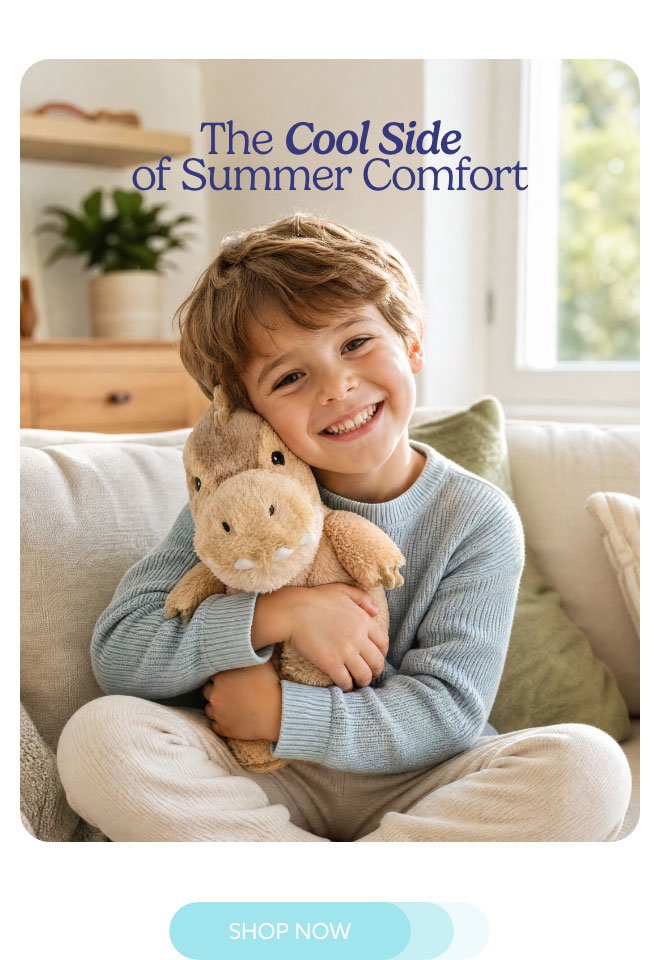 A boy hugging a Megalosaurus Warmies. Shop now.