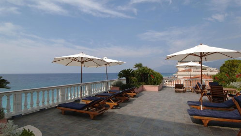 Hotel Terrasse mit Liegen, Sonnenschirmen und Meerblick