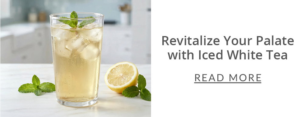 tall glass of iced white tea with a slice of lemon and mint leaves surrounding the glass in a kitchen setting