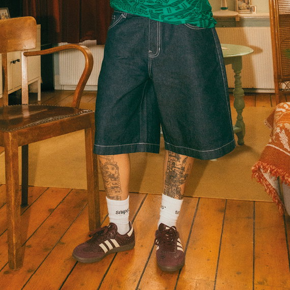 woman in jeans shorts and adidas shoes