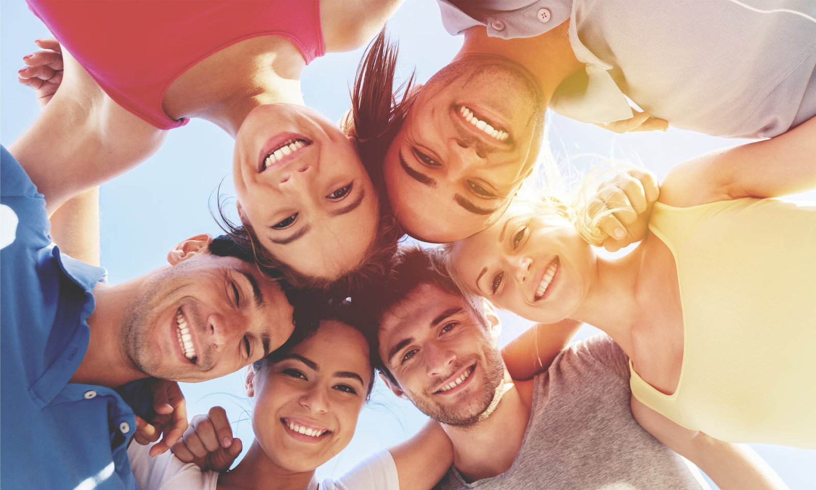 3 men and 3 women in a circle outside smiling