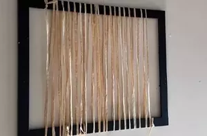 She wraps raffia around a picture frame and weaves it into a mat to make something incredible for summer
