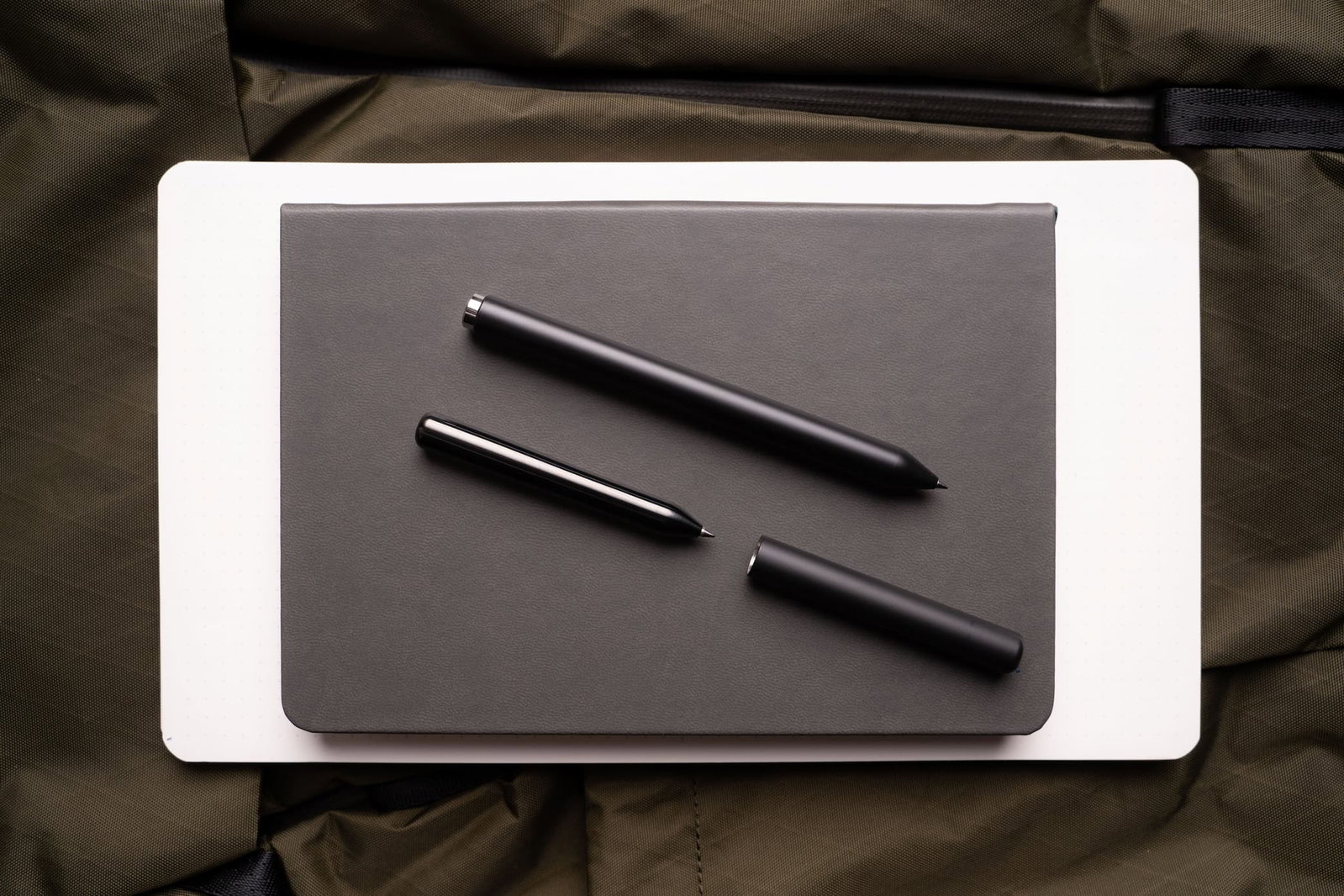 A hand writing with a white Mark One on a Panobook.