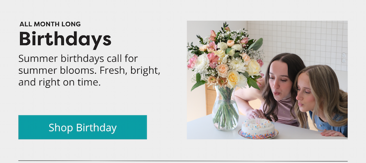 Two women celebrating a birthday with a bouquet and cake