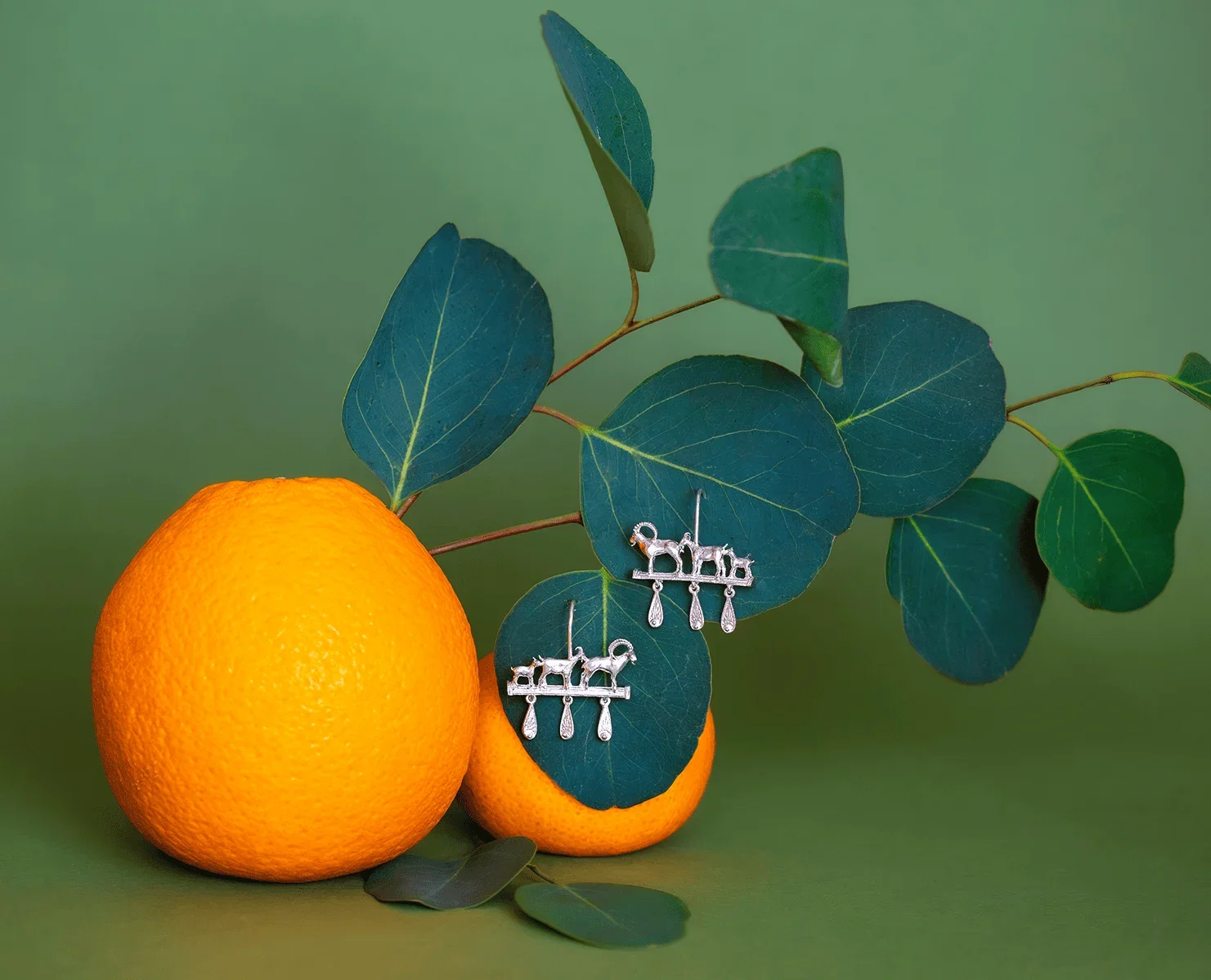 Mountain Goat Family Relic Earrings with Ornate Drops displayed among citrus fruit and eucalyptus leaves for the Summer Archive Sale.