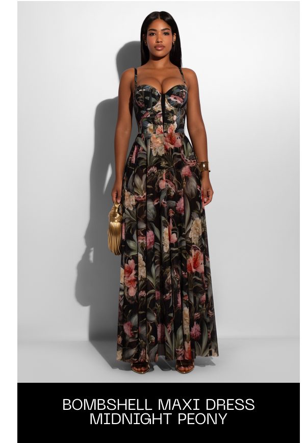 A woman wearing a floral maxi dress with a fitted bodice and flowing skirt.