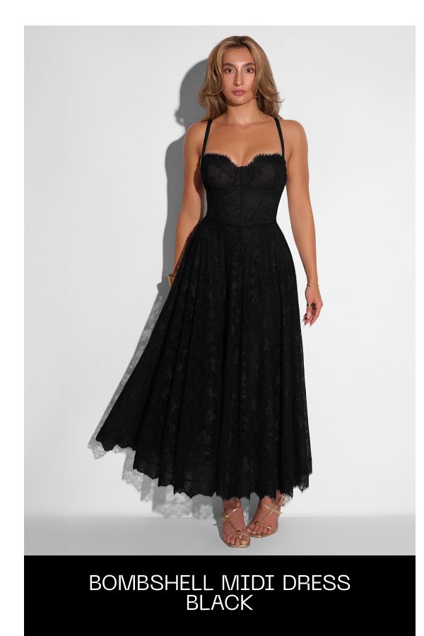 A woman wearing a black bombshell midi dress with a fitted bodice and flowing skirt.