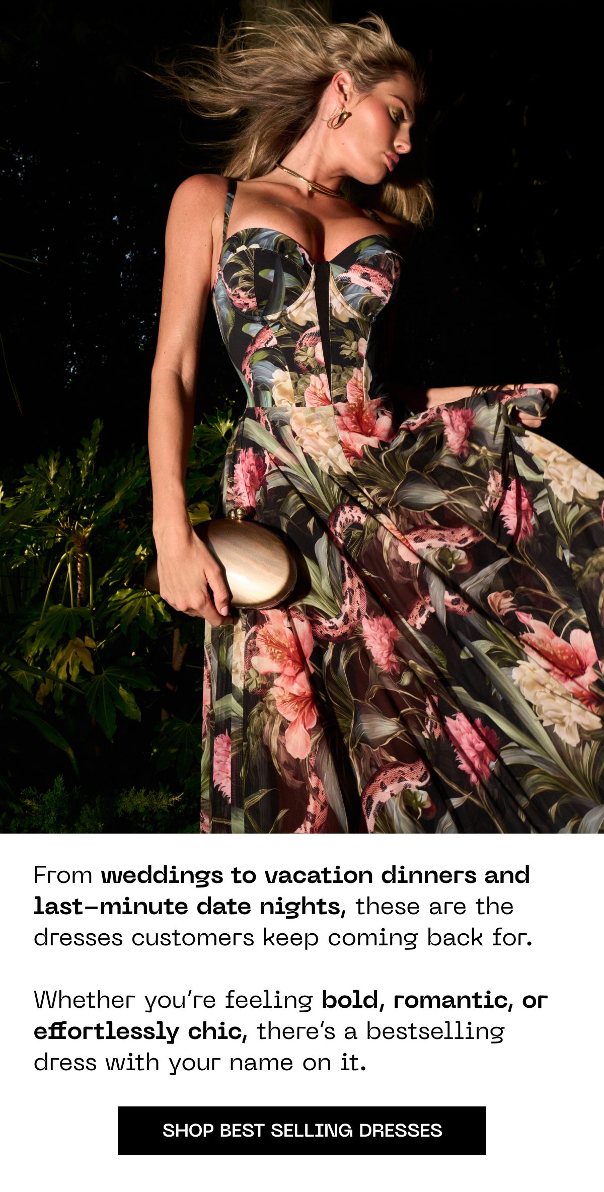 A woman in a floral dress holding a clutch, with greenery in the background.