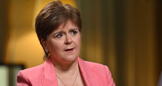 Nicola Sturgeon speaks to Laura Kuenssberg, who is out of shot. Sturgeon is wearing a white top and pink suit.