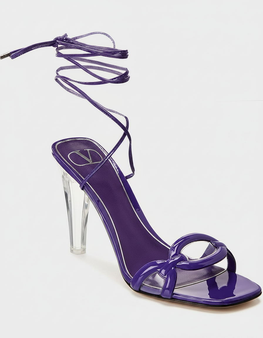 A purple patent leather sandal with a clear heel and ankle straps.