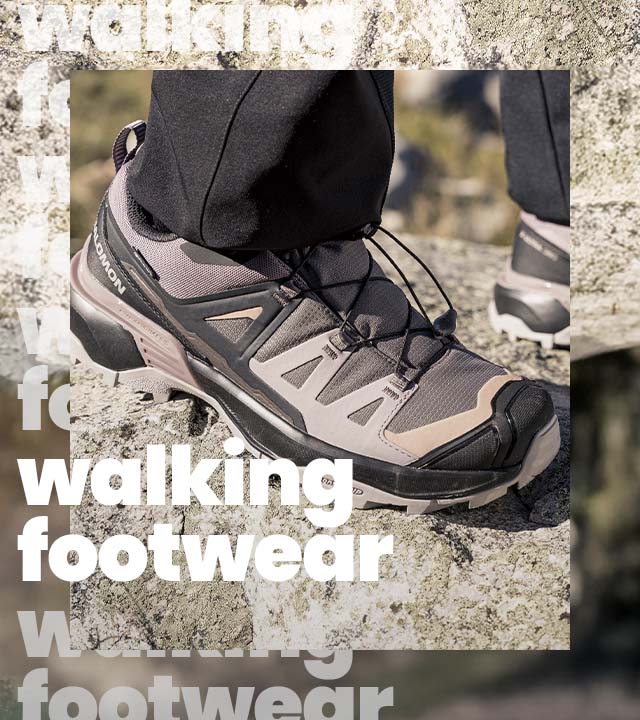 lose-up of a Salomon walking shoe on rocky terrain, highlighting grip and durability, with repeated background text reading 'Walking footwear
