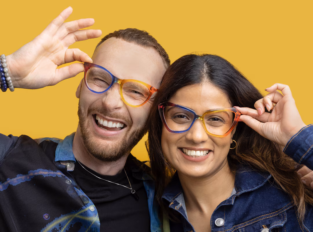 Smiling man and woman wearing the Pride Collection Now and Notice frames