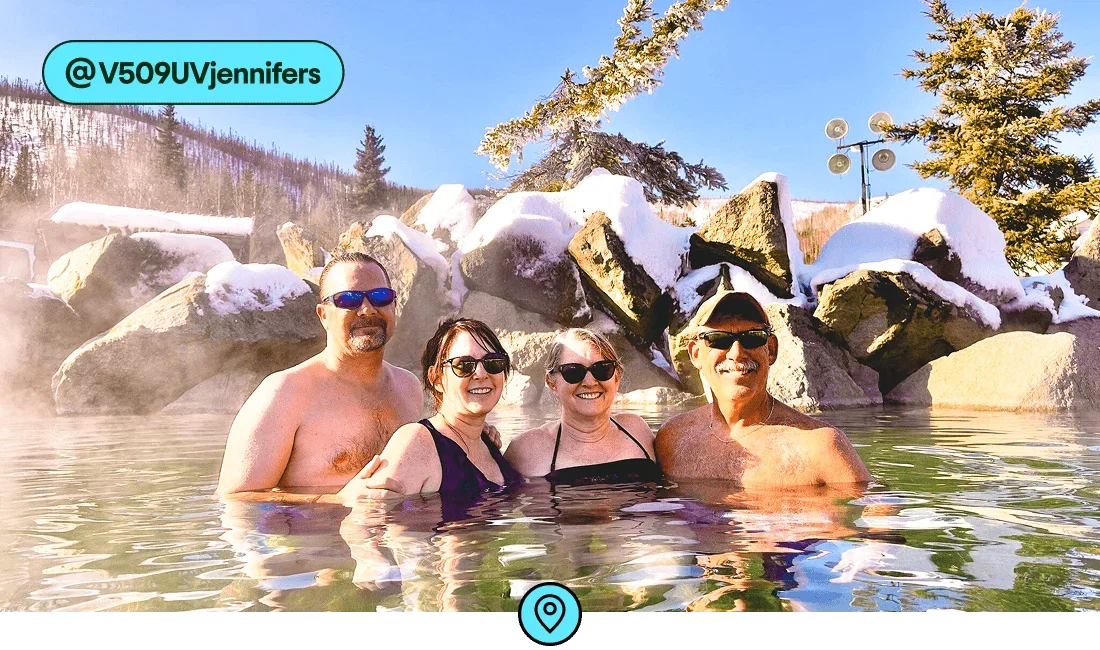 Descripción de la imagen: Un grupo de cuatro personas sumergidas en una fuente termal con rocas cubiertas de nieve detrás de ellas, foto de @V509UVjennifers