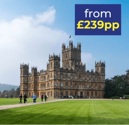 A grand historic building with intricate architecture set against a blue sky and green lawn.