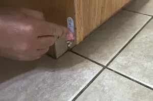 He sticks Command hooks under his kitchen cabinet for a clever trick