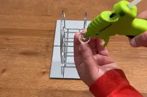 She glues glass gems to a Dollar Tree napkin holder for one of the coolest ideas we've seen all week