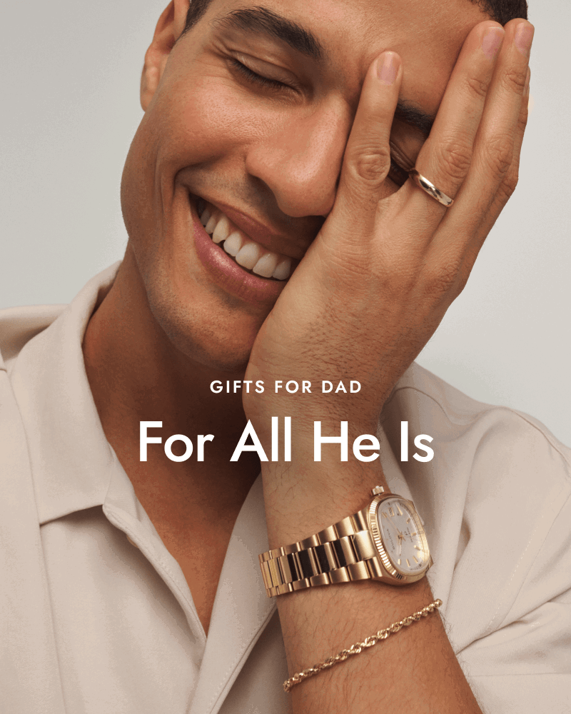 Smiling man with hand on his face wearing gold watch, bracelet and ring. Gifts for Dad: For all he is.