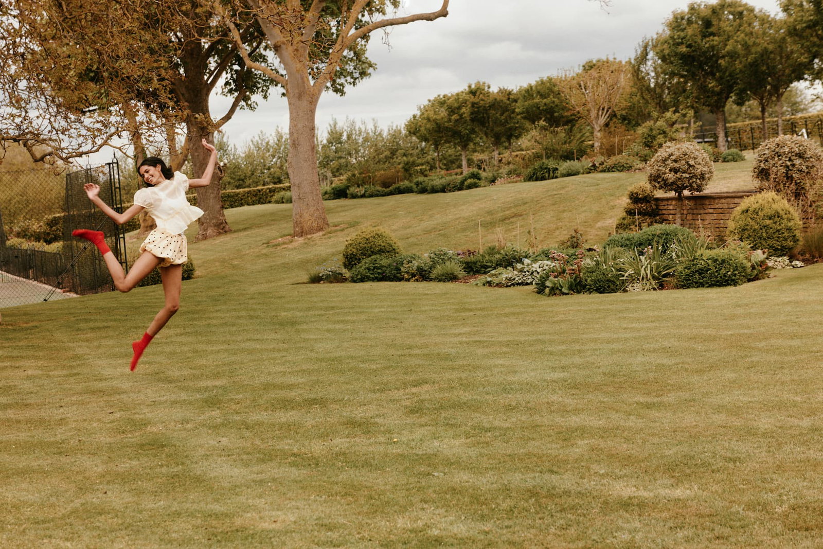 Person jumping in garden wearing red merino socks