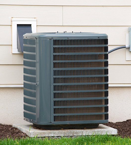Outdoor A/C condenser unit sitting beside a home.
