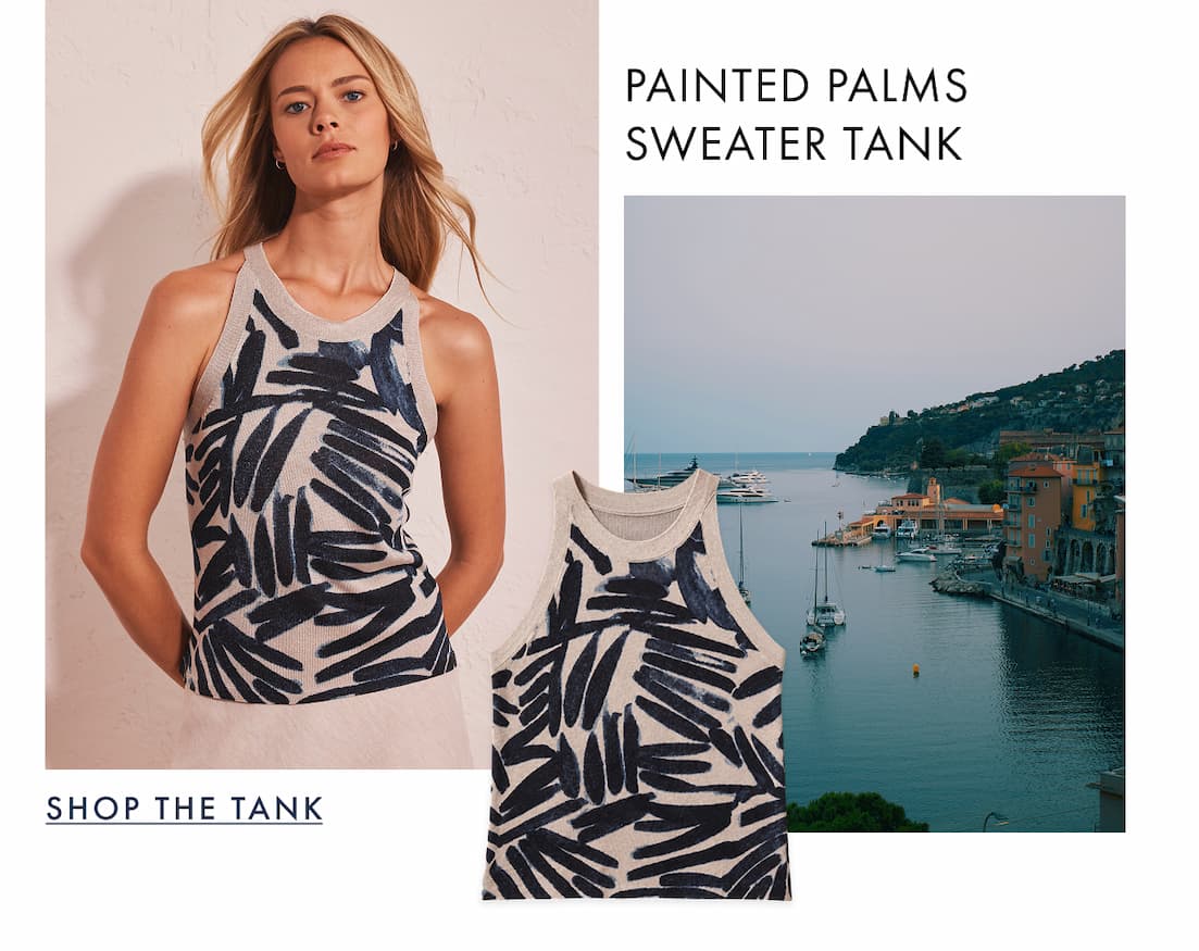 The lady wearing the Painted Palms Sweater Tank. The image showcases stunning waterfront view featuring a few boats on the water.