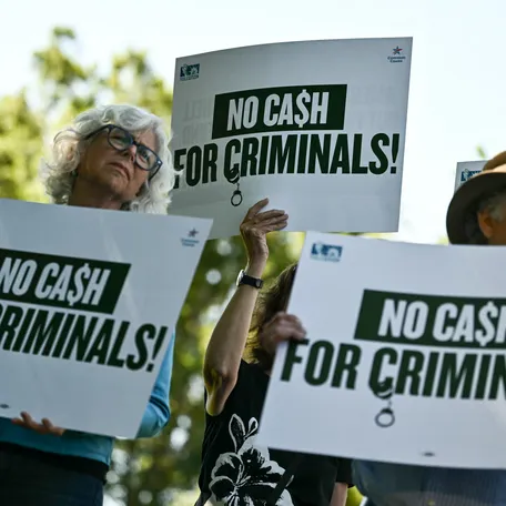 Demonstrators hold signs reading "No cash for criminals" during an event protesting US President Donald Trump's IRS settlement and his "Anti-Weaponization Fund" outside the US Capitol building in Washington, DC, on June 2, 2026.