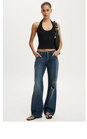 Woman wearing black halter top and distressed dark denim jeans