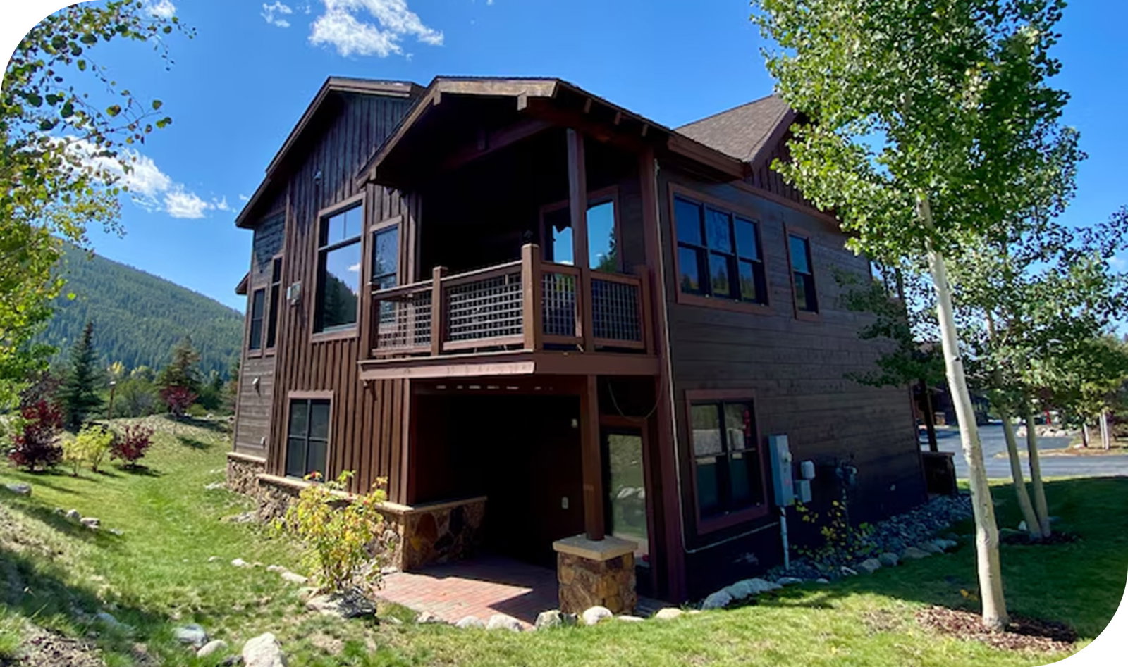 Multi‑story wooden mountain lodge with angular rooflines and forested hillside views.