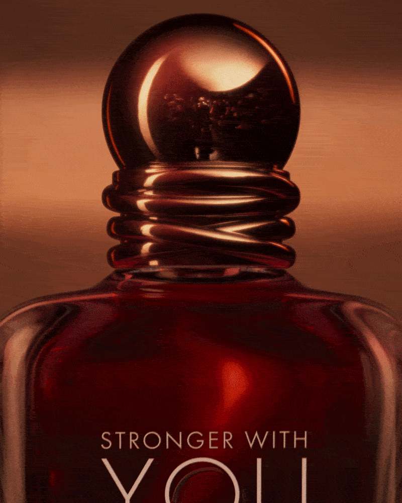 Close-up of the Emporio Armani Stronger With You Parfum bottle against a warm amber background.