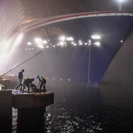 Workers secure the lines as Carnival Mardis Gras docks at Terminal 3. Cruise ships came into Port Canaveral blaring their fog horns on an extremely foggy morning.