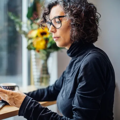 Person using smartphone and laptop.