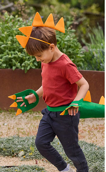 Dinosaur Dig from Koala Crate. Image of young boy dressed in a build-your-own dinosaur costume, complete with felt spikes, claws, and tail.