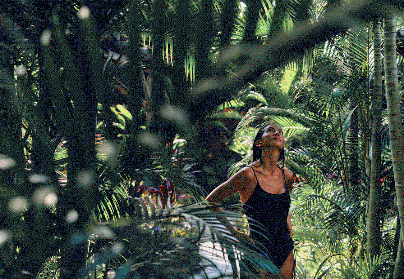 Hero GIF featuring 5 frames: 1) Woman in a bathing suit standing among jungle foliage. 2) View over Kings Pond, with an infinity pool and ocean beyond. 3) Family paddling an outrigger canoe on the water. 4) Couple walking hand in hand along a beach at sunset. 5) Staff member presenting a colourful drink to a seated guest at an intimate beach table at dusk.