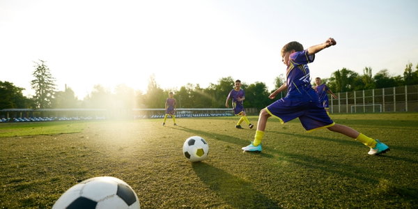 Kind, das Fußball spielt.