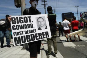 A protester holds a sign with a photo of former Minneapolis police officer Derek Chauvin during demonstrations following the death of George Floyd on May 30, 2020 in Los Angeles, California.