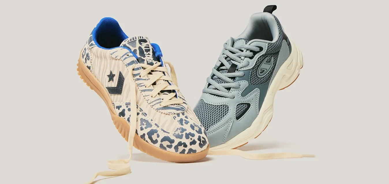 Deux baskets aux lacets défaits flottant côte à côte ; l'une en mesh bleu-gris et l'autre beige avec imprimé animalier et semelle en gomme.