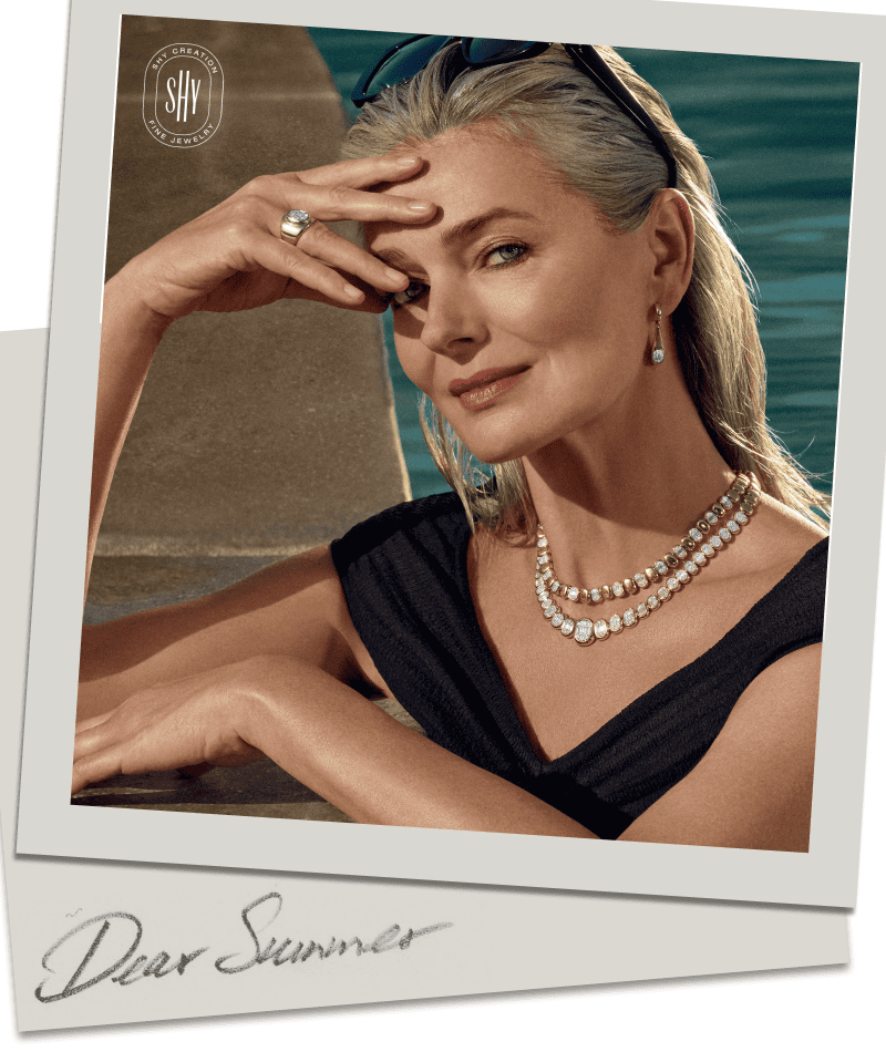Model wearing jewelry in pool. 