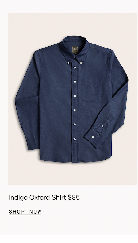 Flat lay of an indigo button-down dress shirt with a single chest pocket and white buttons. Indigo $85 SHOP NOW