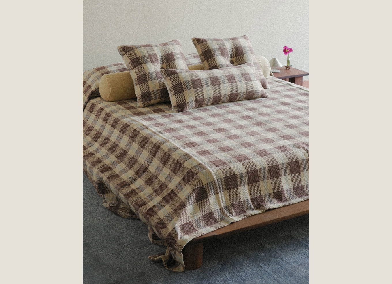 Bed styled with matching brown check blanket and throw pillows