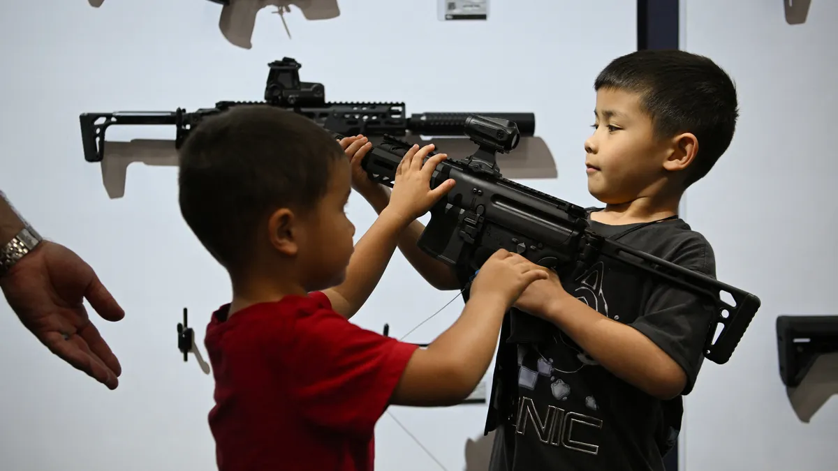 Children interact with guns on display during the National Rifle Association's annual meetings and exhibits in Houston on April 17, 2026.