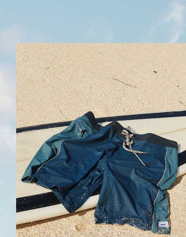 OTG Archer Surf Trunk laying on surfboard