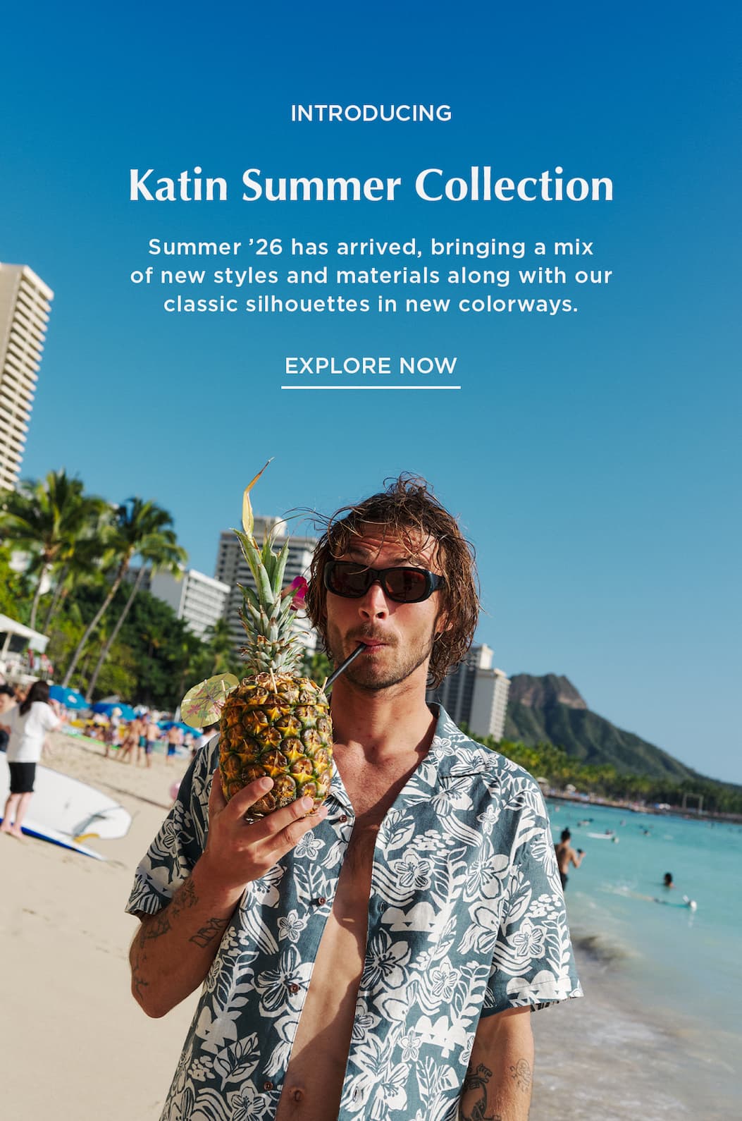Male Model on the beach drinking from a Pineapple