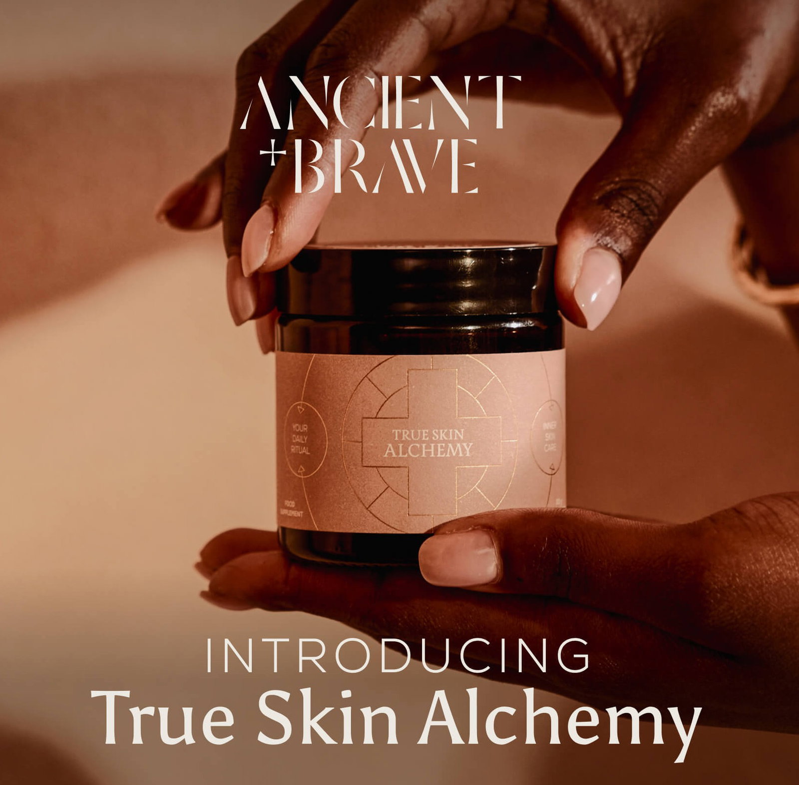 Ancient + Brave | Introducing True Skin Alchemy — hands cradling a dark glass jar of True Skin Alchemy supplement against a warm terracotta background