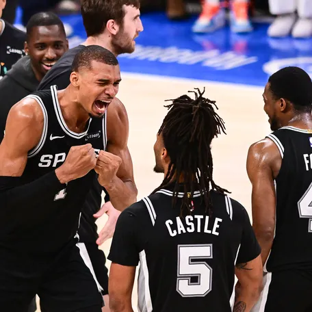 Victor Wembanyama of the San Antonio Spurs celebrates with Stephon Castle and De'aaron Fox after defeating the Oklahoma City Thunder with a score of 111-103 to win Game Seven of the NBA Western Conference Finals at Paycom Center on May 30, 2026, in Oklahoma City.