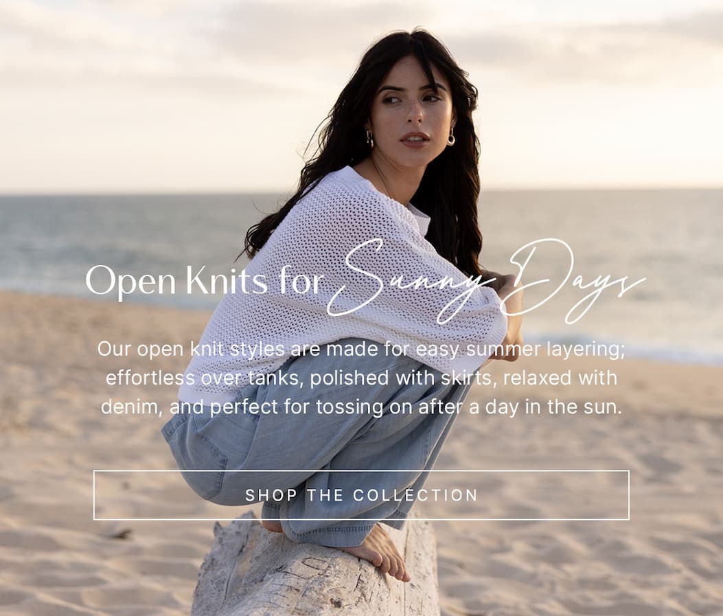 Model wearing a cream open-knit sweater outdoors on stone steps, with overlay text reading “Shop the Collection.”