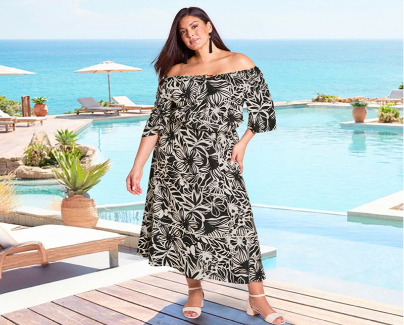 Ein Model trägt ein schwarz-sand-bedrucktes Maxikleid mit floralem Alloverdruck