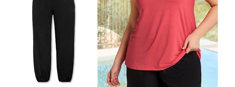 Ein Model trägt ein hummer farbenes Shirttop mit Bindeband im Nacken und eine schwarze Schlupfhose mit Smokbund