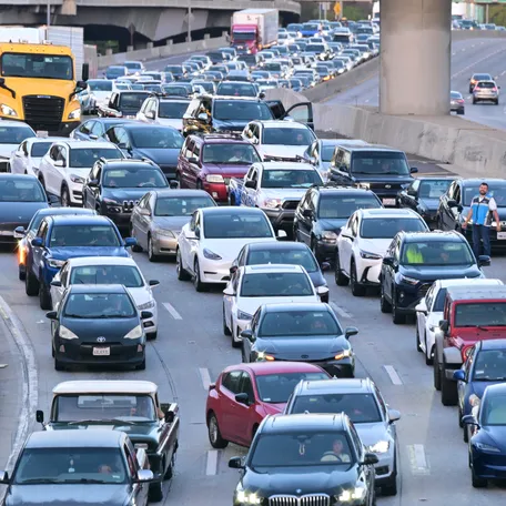 A driver steps out of his vehicle (R) as traffic comes to a standstill on a Los Angeles freeway on April 28, 2026. (Photo by Frederic J. BROWN / AFP via Getty Images)