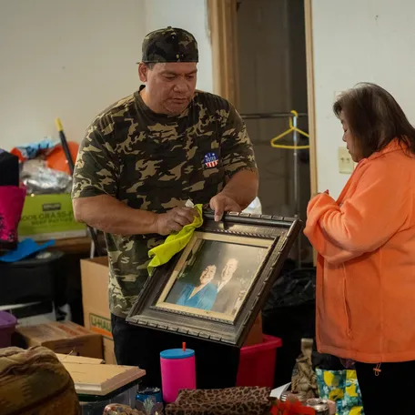 Elizabeth Oshiro and her husband Jack Fidow pack an old photo of her parents in the home she inherited from her mother.