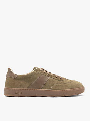 Side view of a brown suede trainer with a flat sole on a white background.