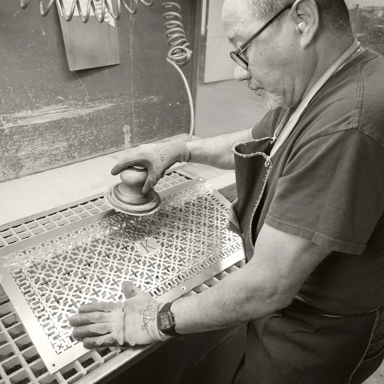 A man burnishes a custom monogrammed grille